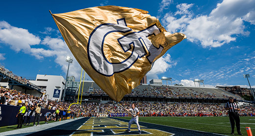 Photo of a GT flag waving at a football game.